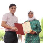 President Halimah Yacob presenting a certificate of appreciation to Singapore General Hospital