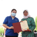 President Halimah Yacob presenting a certificate of appreciation to Tan Tock Seng