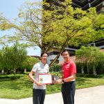 Donor and KWSH CEO in front of historic tree planted by Mr Lee Kuan Yew